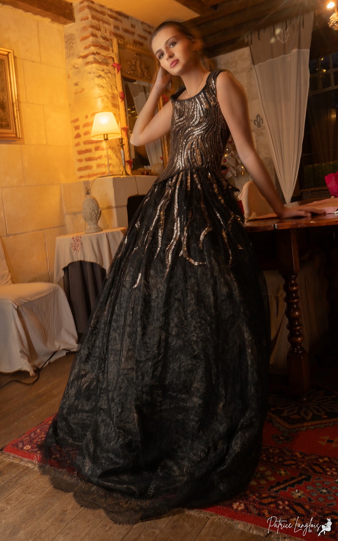Robe d'apparat noire brodée de blanc devant un château de la Loire.