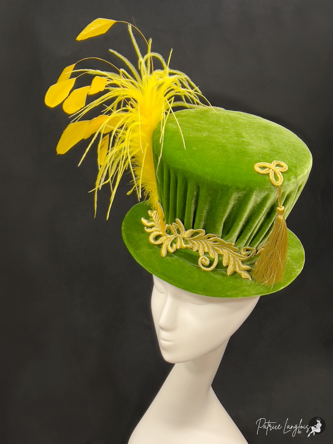 Chapeau haut-de-forme en velours vert orné de plumes.